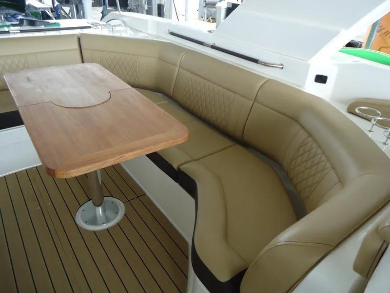 Slide: The Image of Luxurious seating area on 2022 Sea Ray 350 SLX boat with wooden table and tan upholstery. - 10