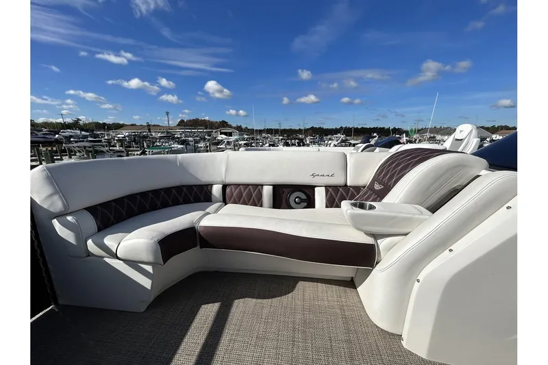 Slide: The Image of 2021 Bennington QX 25 Swingback boat interior with luxurious seating at marina. - 10