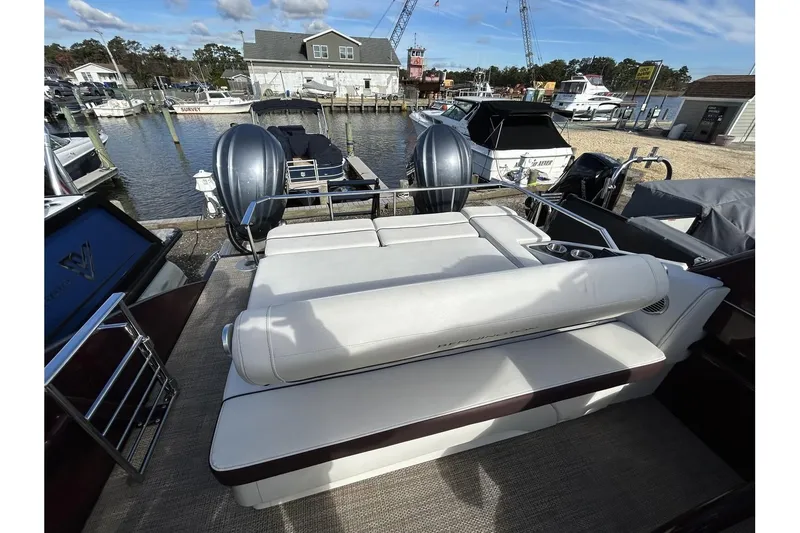 Slide: The Image of 2021 Bennington QX 25 Swingback boat with dual engines docked at a marina. - 29