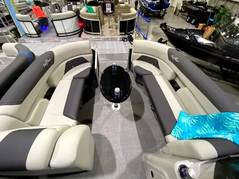 Slide: The Image of 2024 SunChaser Geneva 24 SB DH pontoon boat interior with plush seating and table. - 15