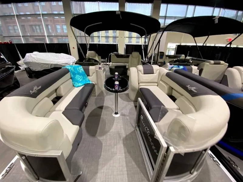 Slide: The Image of 2024 SunChaser Geneva 24 SB DH pontoon boat interior with plush seating and table. - 6