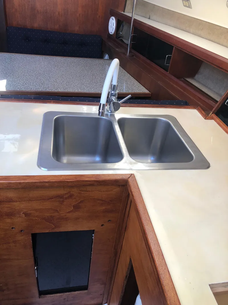 Slide: The Image of 1983 Hunter 34 yacht kitchen with dual sink and wooden cabinetry. - 10