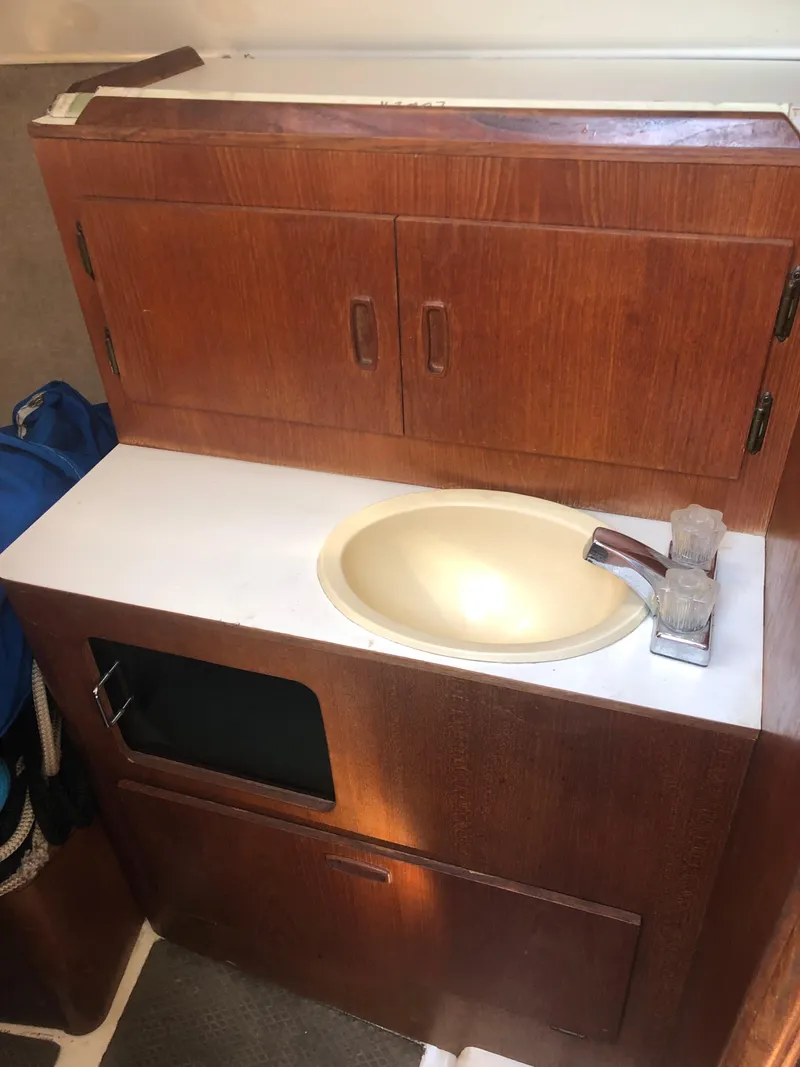 Slide: The Image of 1983 Hunter 34 sailboat bathroom sink with wooden cabinetry and modern faucet. - 12
