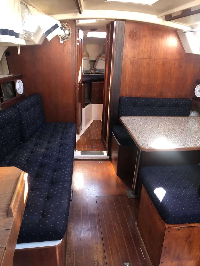 Slide: The Image of Interior of 1983 Hunter 34 sailboat with wooden finish and blue upholstered seating. - 13