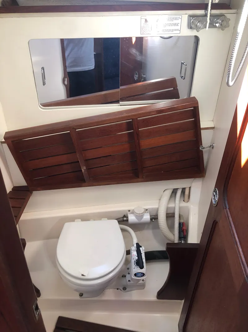 Slide: The Image of 1983 Hunter 34 sailboat bathroom with wooden accents and compact toilet. - 16