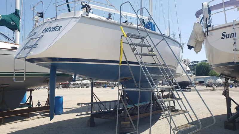 Slide: The Image of 1983 Hunter 34 sailboat on dry dock with ladder access. - 2