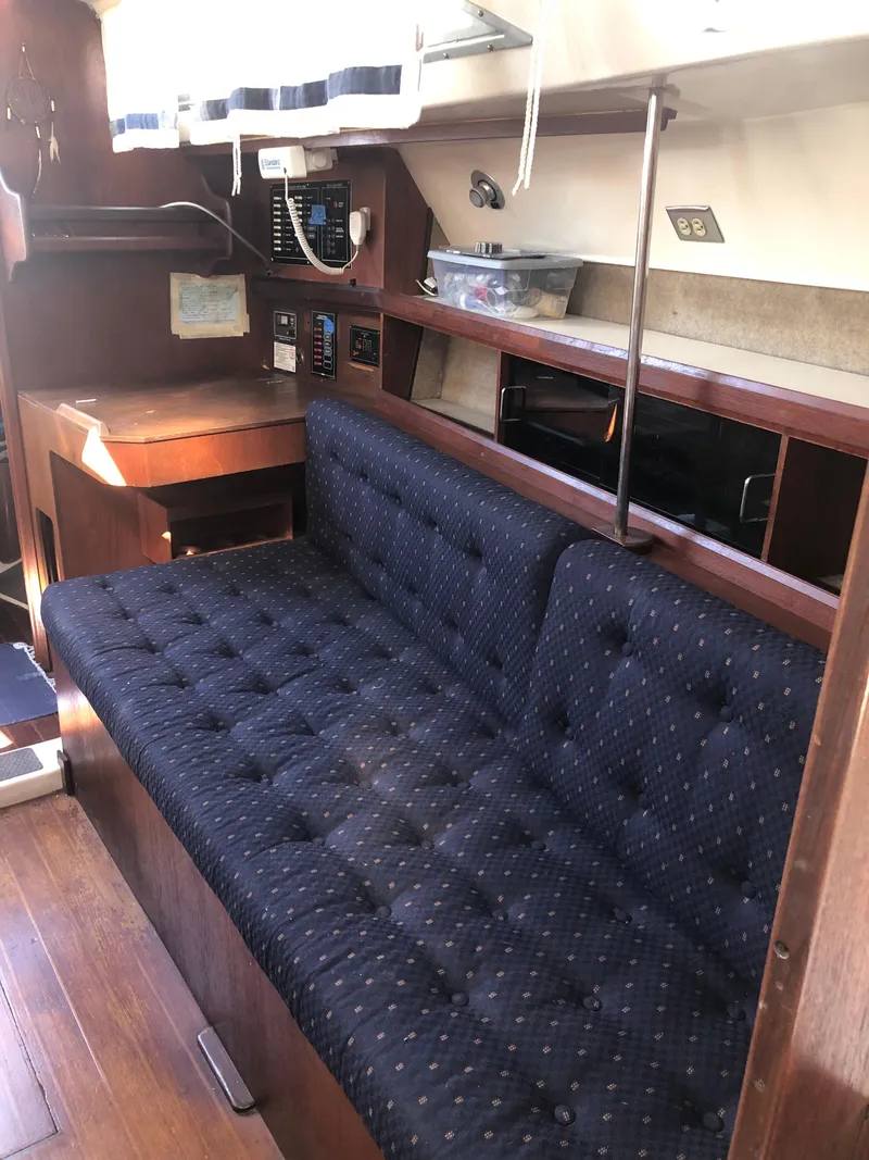 Slide: The Image of Interior of 1983 Hunter 34 sailboat with navy cushioned seating and wooden cabinetry. - 22