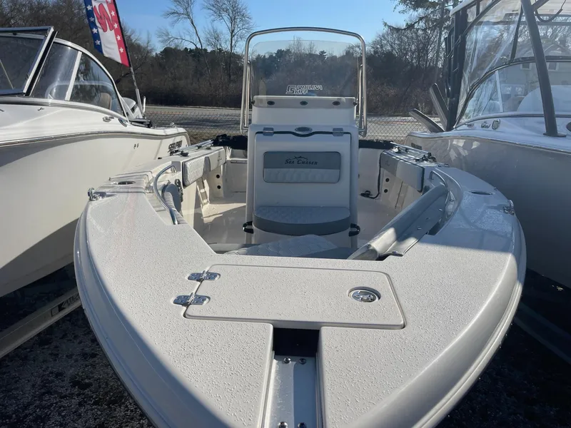 Slide: The Image of 2024 Sea Chaser 20 HFC boat, white exterior, docked between other boats. - 7