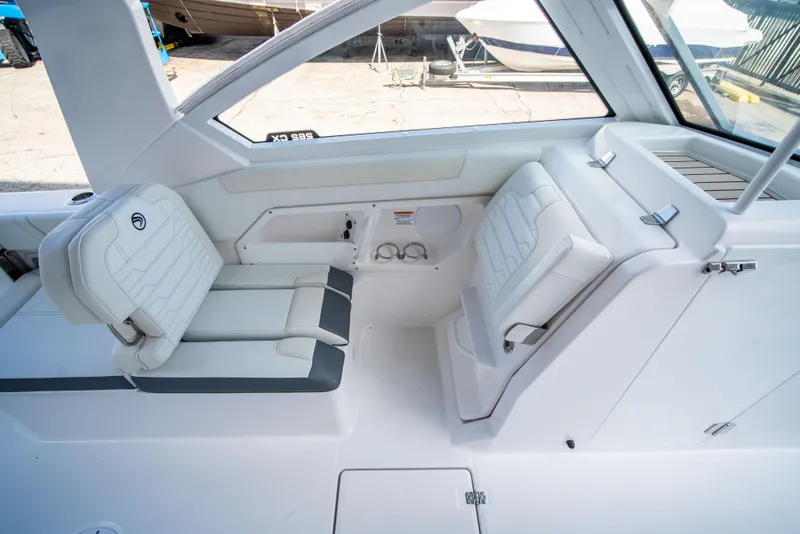 Slide: The Image of 2024 Edgewater 262 CX boat interior with white and gray seating. - 11