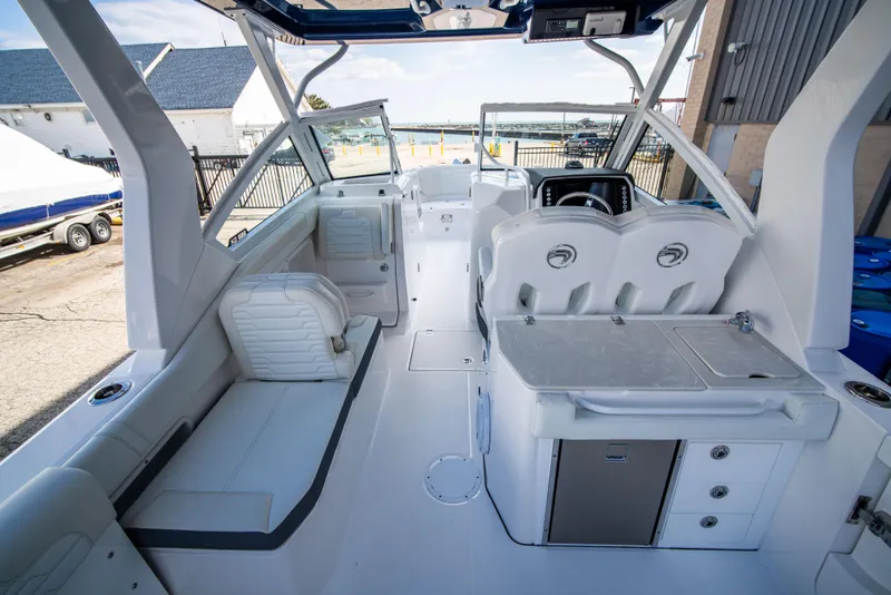 Slide: The Image of 2024 Edgewater 262 CX boat interior with seating, helm, and kitchenette. - 12