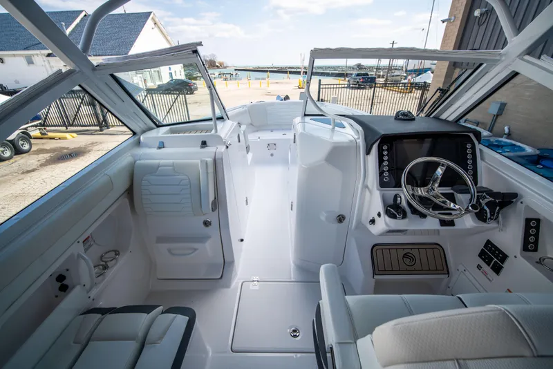 Slide: The Image of 2024 Edgewater 262 CX boat interior with helm and seating area. - 13