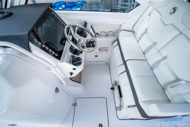 Slide: The Image of 2024 Edgewater 262 CX boat cockpit with white seating and modern dashboard. - 15