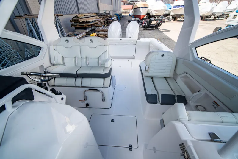 Slide: The Image of 2024 Edgewater 262 CX boat interior with white seating and dual outboard motors. - 2