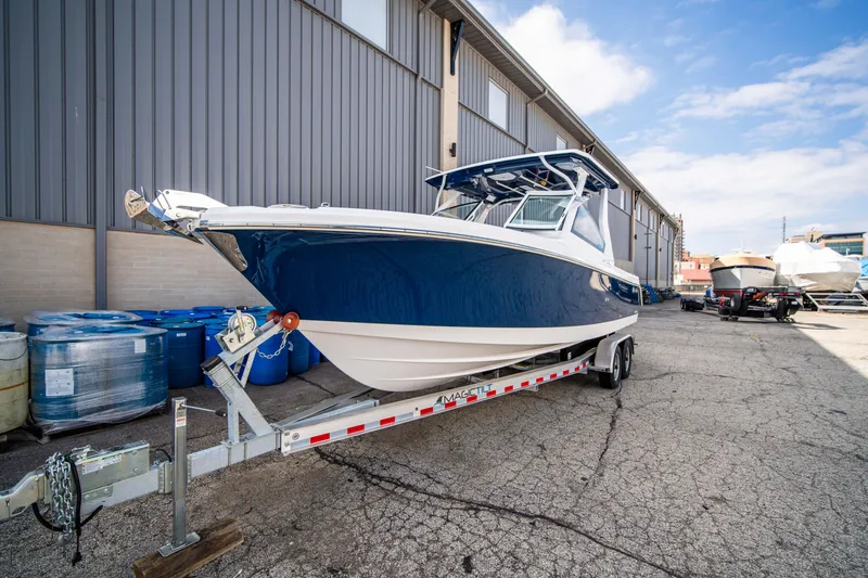 Slide: The Image of 2024 Edgewater 262 CX boat on a trailer outside a warehouse. - 4