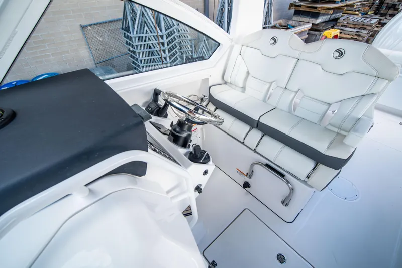 Slide: The Image of 2024 Edgewater 262 CX boat cockpit with dual seats and steering wheel. - 7