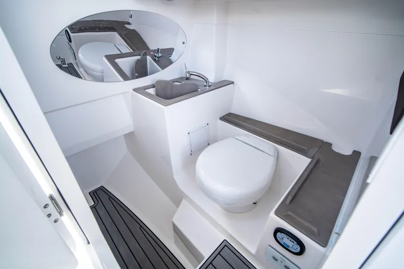 Slide: The Image of 2024 Edgewater 262 CX boat interior bathroom with sink, toilet, and seating. - 9