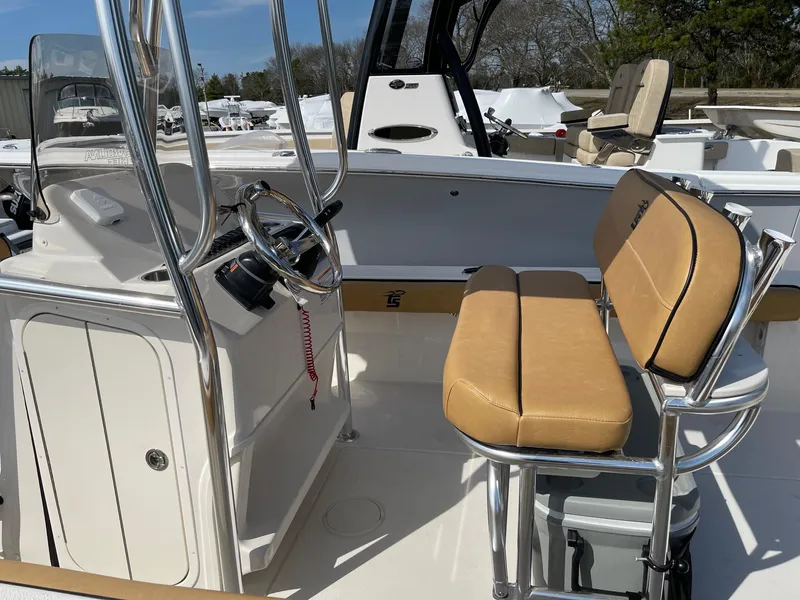 Slide: The Image of 2024 Carolina Skiff 24 Ultra Elite boat interior with tan seating and steering console. - 5