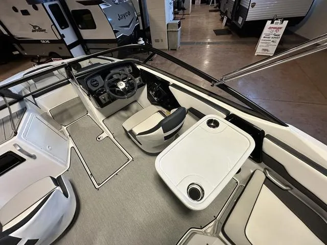 Slide: The Image of 2024 Yamaha Boats SX195 interior with steering console, seating, and table. - 9