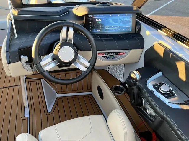 Slide: The Image of 2022 Nautique G23 boat cockpit with modern steering wheel and digital dashboard display. - 15