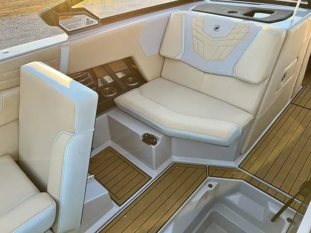 Slide: The Image of Luxurious interior of 2022 Nautique G23 boat with beige seating and wood accents. - 17