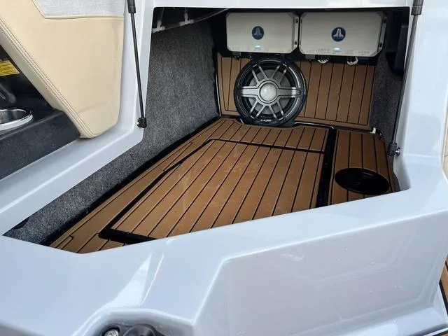 Slide: The Image of 2022 Nautique G23 boat interior with wood flooring and speaker system. - 19