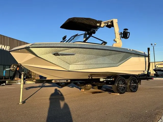 Slide: The Image of 2022 Nautique G23 boat on trailer in sunny outdoor setting. - 2