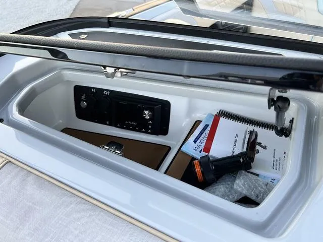 Slide: The Image of 2022 Nautique G23 storage compartment with manuals and accessories. - 23