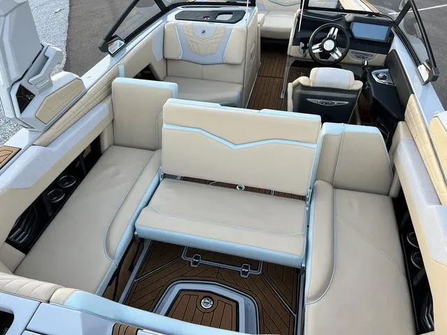 Slide: The Image of 2022 Nautique G23 boat interior with beige seating and modern dashboard. - 24