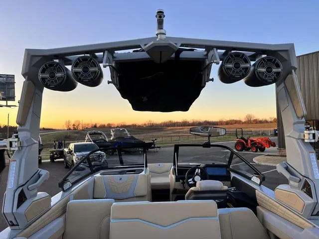 Slide: The Image of 2022 Nautique G23 boat interior with speakers, sunset view in the background. - 25