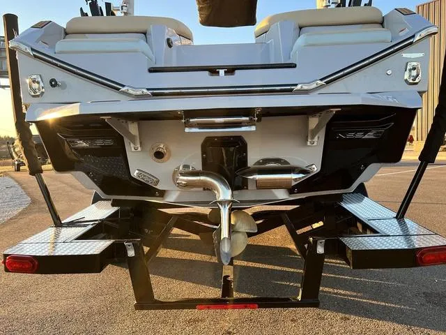 Slide: The Image of 2022 Nautique G23 boat rear view with platform and exhaust details. - 7