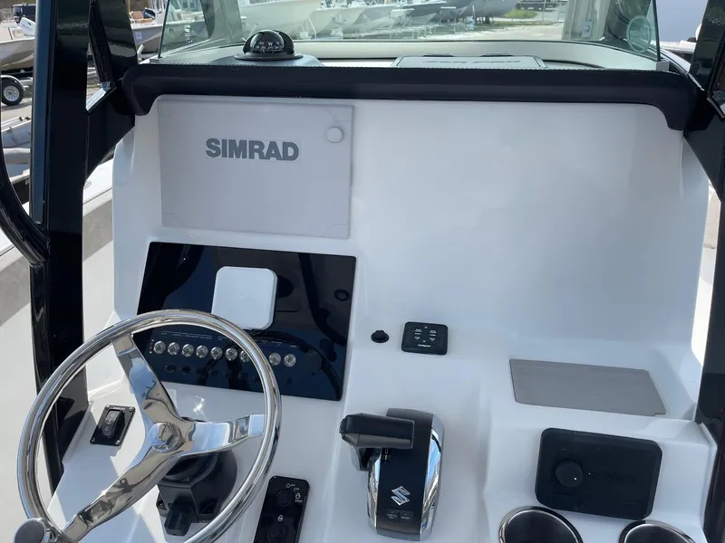Slide: The Image of 2024 Sea Pro 242 Center Console boat dashboard with Simrad electronics and Suzuki controls. - 10