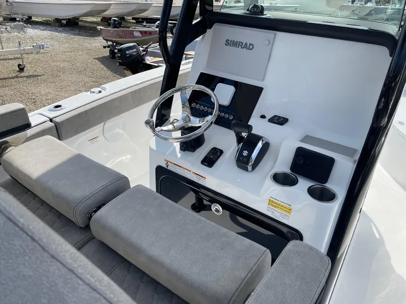 Slide: The Image of 2024 Sea Pro 242 Center Console boat helm with Simrad electronics and cushioned seating. - 5
