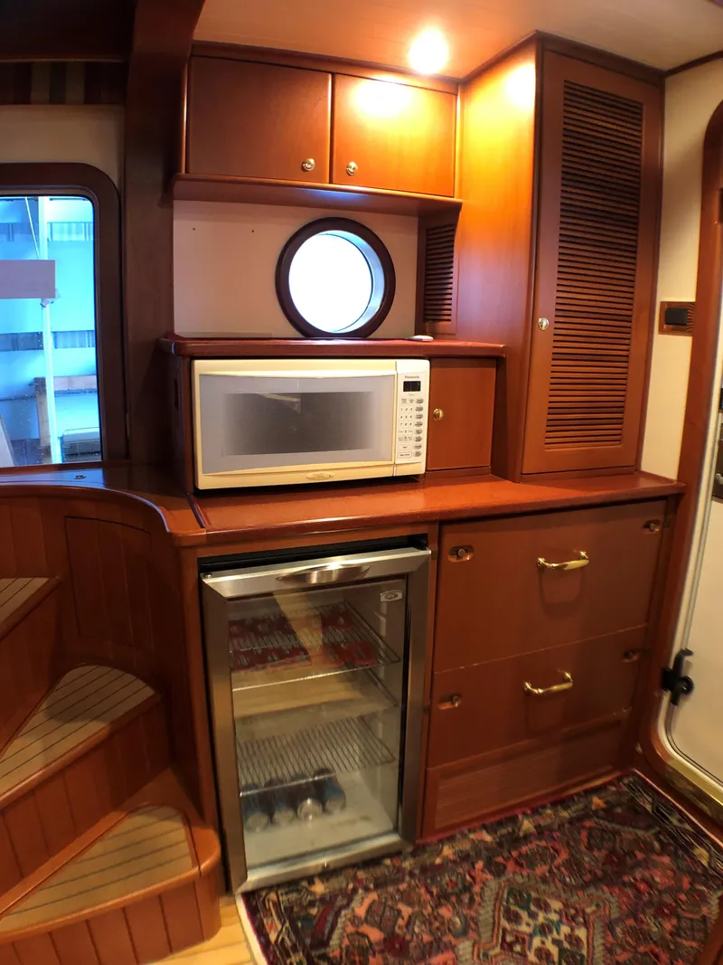 Slide: The Image of Cozy North Sea trawler kitchen with microwave, mini-fridge, and wooden cabinetry, 2002 model. - 17