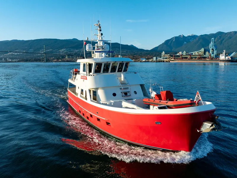 Slide: The Image of Red North Sea Trawler boat cruising in scenic waters, mountains in the background, 2002 model. - 3
