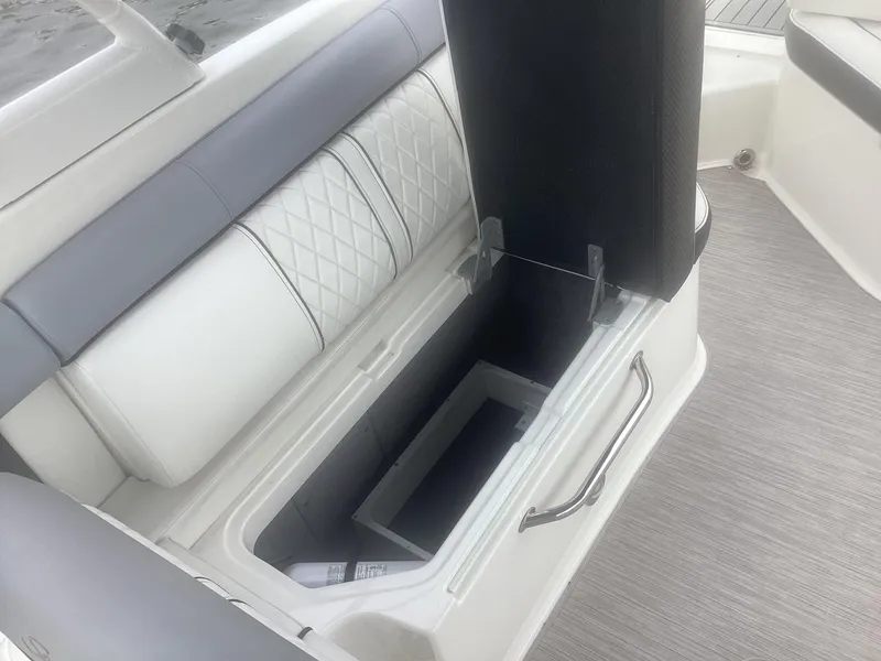 Slide: The Image of 2017 Sea Ray SDX 270 boat interior with open storage compartment and cushioned seating. - 21