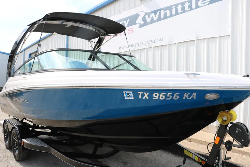 Slide: The Image of 2021 Regal 2000 ESX Bowrider boat on trailer, blue and white exterior. - 12