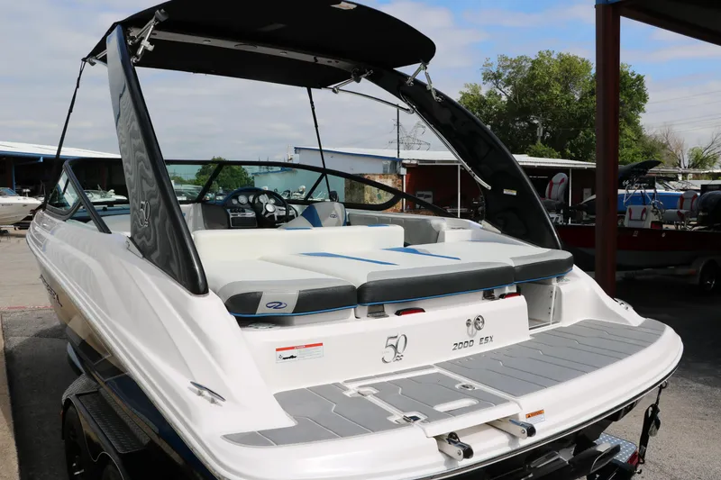 Slide: The Image of 2021 Regal 2000 ESX Bowrider boat with black canopy and white seating. - 7