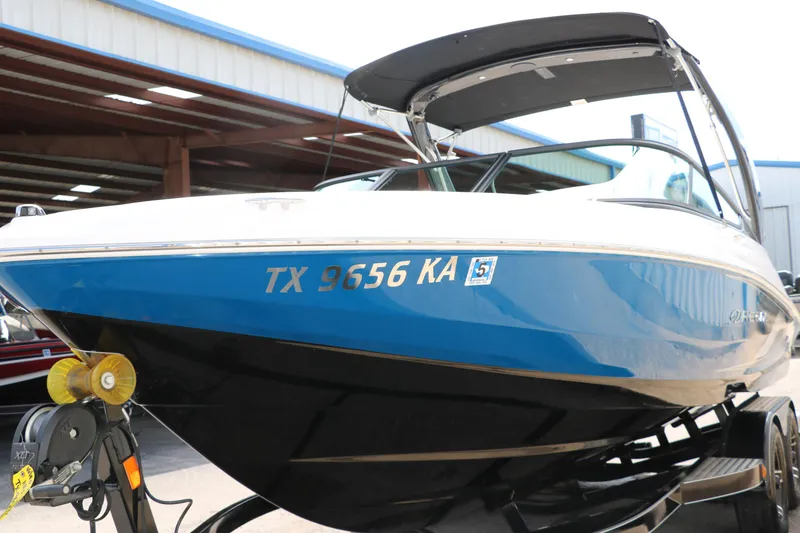 Slide: The Image of 2021 Regal 2000 ESX Bowrider boat on trailer, blue and white hull. - 9