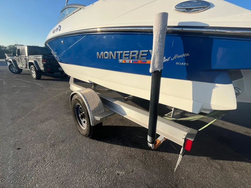 Slide: The Image of 2020 Monterey M205 boat on trailer, blue and white, parked in a lot. - 19