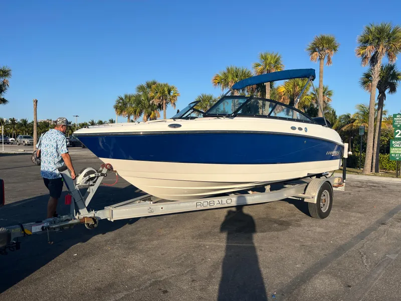 Slide: The Image of 2020 Monterey M205 boat on a trailer in a sunny parking lot with palm trees. - 2