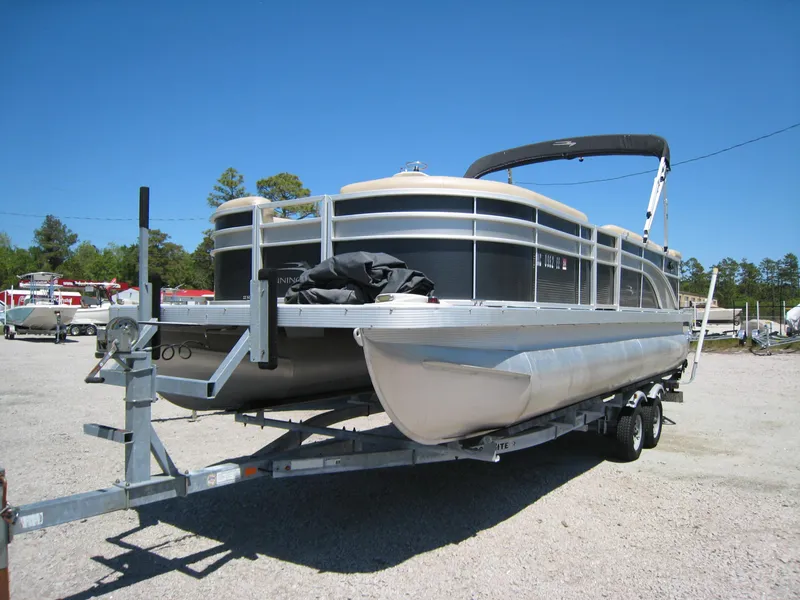 Slide: The Image of 2017 Bennington 22SLX pontoon boat on a trailer in a parking lot. - 1