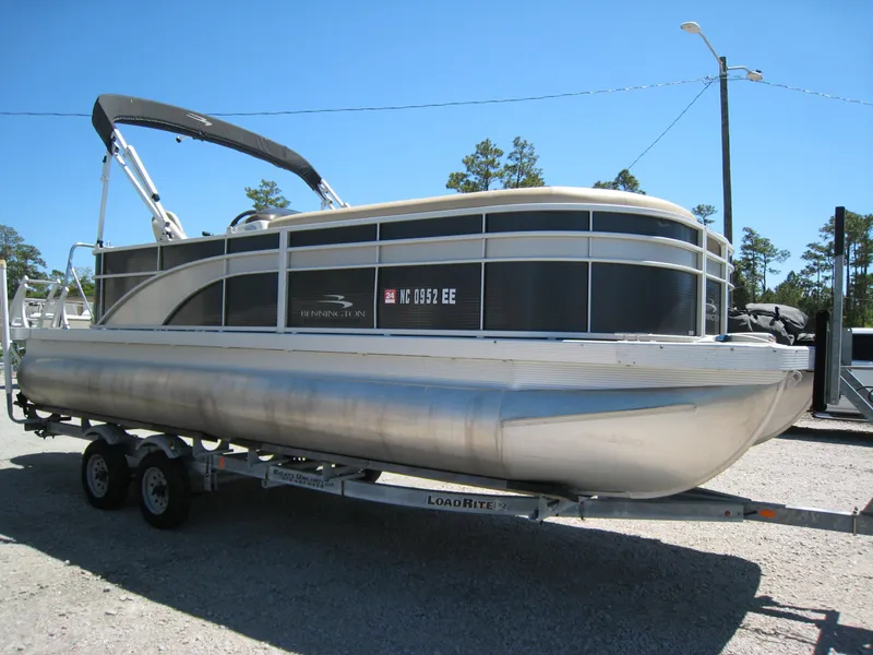 Slide: The Image of 2017 Bennington 22SLX pontoon boat on a trailer under a clear blue sky. - 2