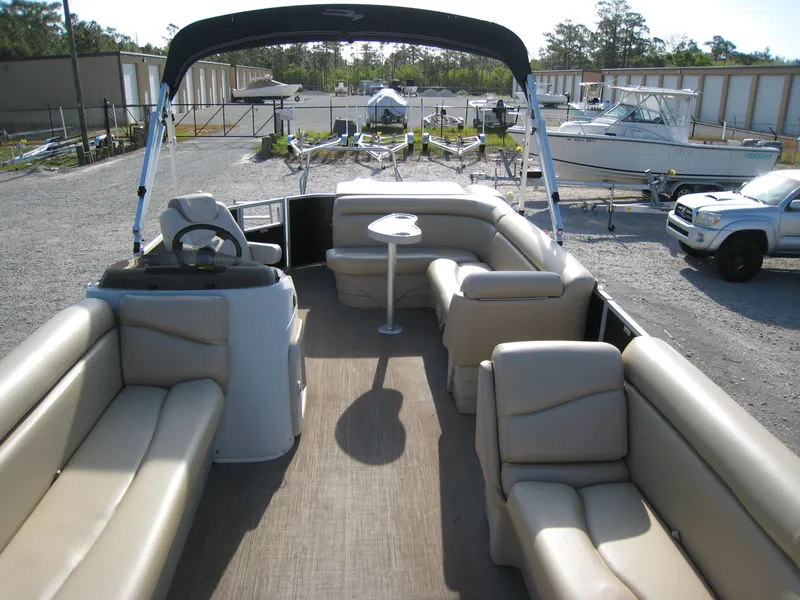 Slide: The Image of 2017 Bennington 22SLX pontoon boat with beige seating and canopy in a marina. - 7