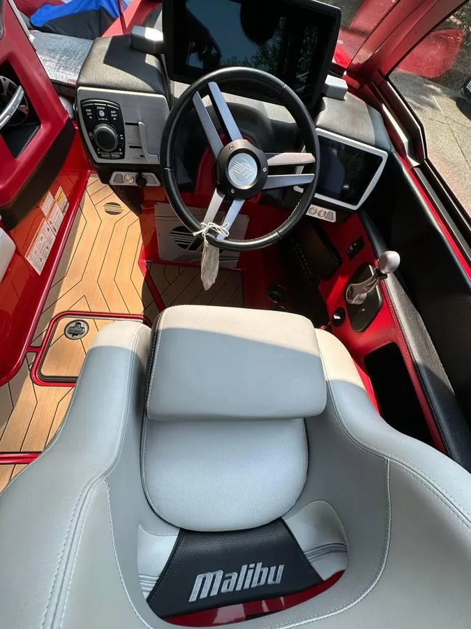 Slide: The Image of 2017 Malibu 24' WAKESETTER MXZ boat interior with steering wheel and dashboard. - 12