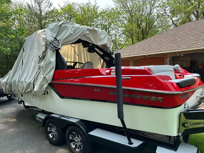 Slide: The Image of 2017 Malibu 24' WAKESETTER MXZ boat with cover, parked on a trailer in a driveway. - 13