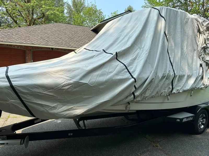 Slide: The Image of 2017 Malibu 24' WAKESETTER MXZ boat covered with a protective tarp on a trailer. - 14
