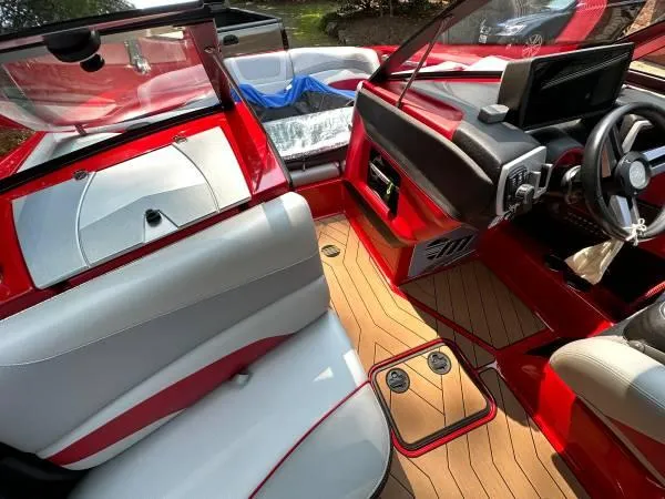 Slide: The Image of 2017 Malibu 24' WAKESETTER MXZ interior with red and white seating, dashboard, and teak flooring. - 18