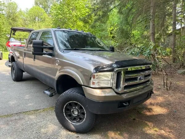 Slide: The Image of Ford truck towing a 2017 Malibu 24' WAKESETTER MXZ boat in a wooded area. - 21