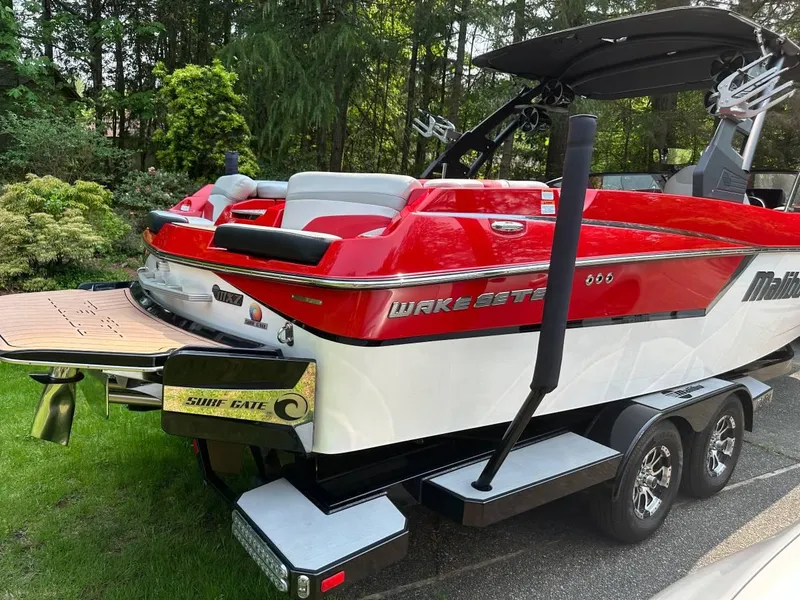 Slide: The Image of 2017 Malibu 24' WAKESETTER MXZ boat with red and white exterior, on a trailer. - 5