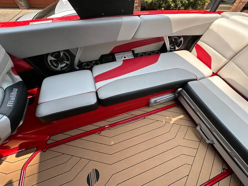 Slide: The Image of 2017 Malibu 24' WAKESETTER MXZ interior seating with red and gray upholstery. - 8